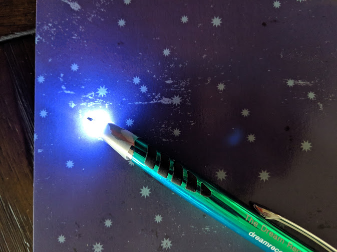 A light pen with a piece of tape on the end to dim the light.