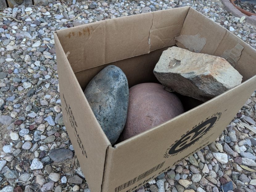 A cardboard box with big rocks in it.