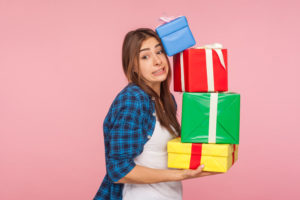 Woman carrying four wrapped gifts.