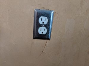 an electrical wall outlet in an adobe wall