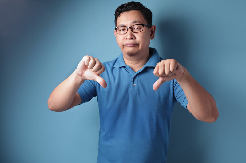 Man giving thumbs down sign.