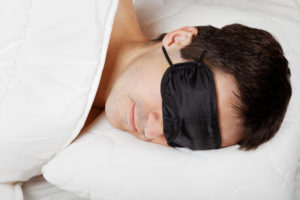 sleeping man wearing sleep mask