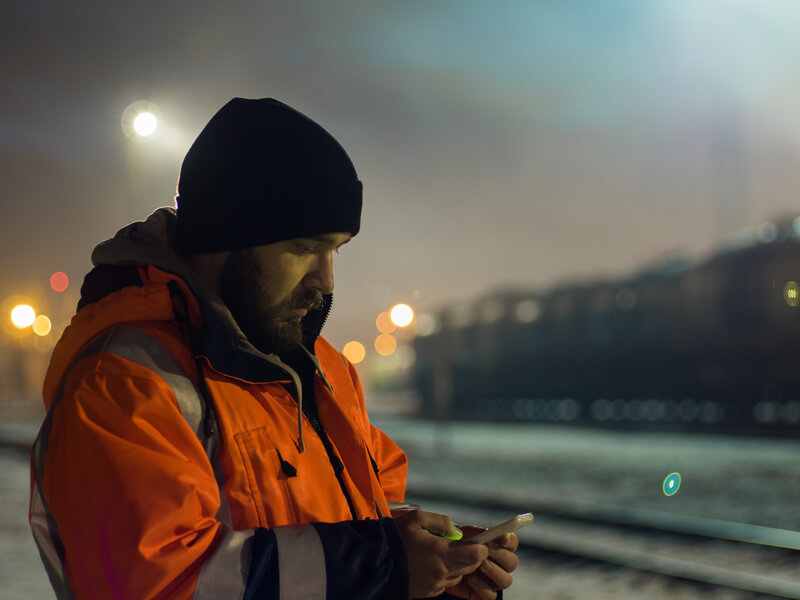 Man gets message on phone while working at night.