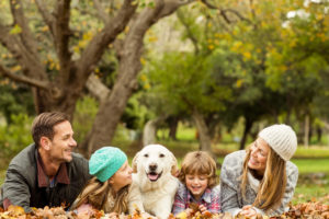 A white family dog with four members of his family.