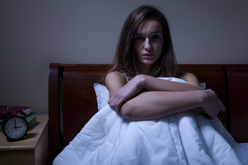 woman sitting in bed in the middle of the night