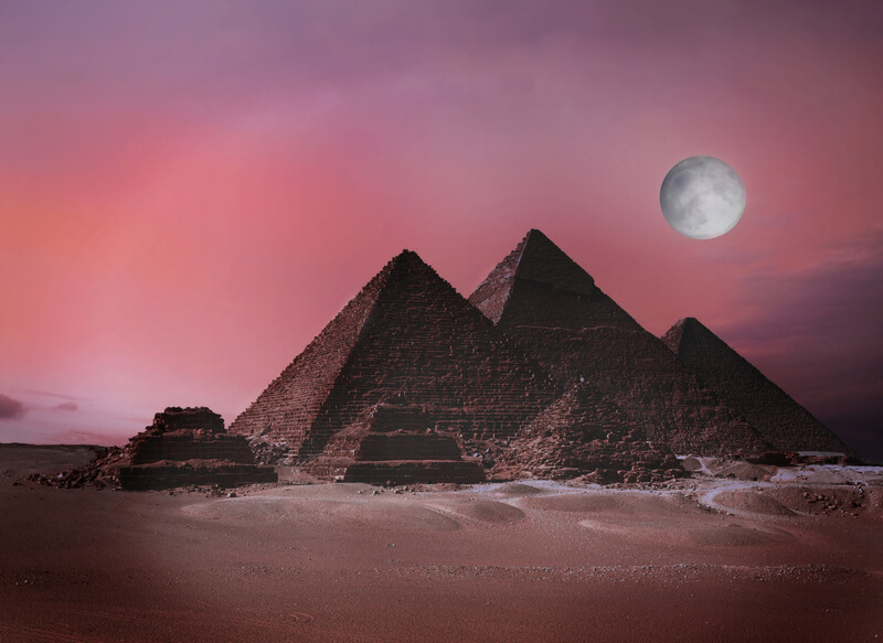 moon rises over the pyramids in Egypt