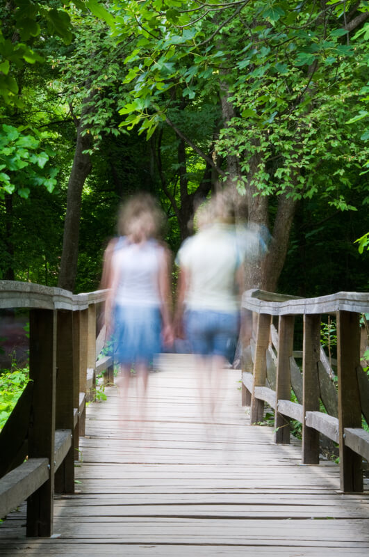 blurry photo of two girls walking on a bridge